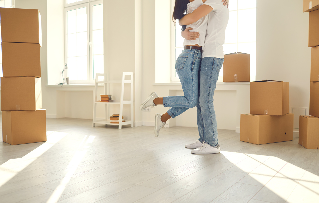 Happy Family Couple Hugs Dancing in a New Apartment.